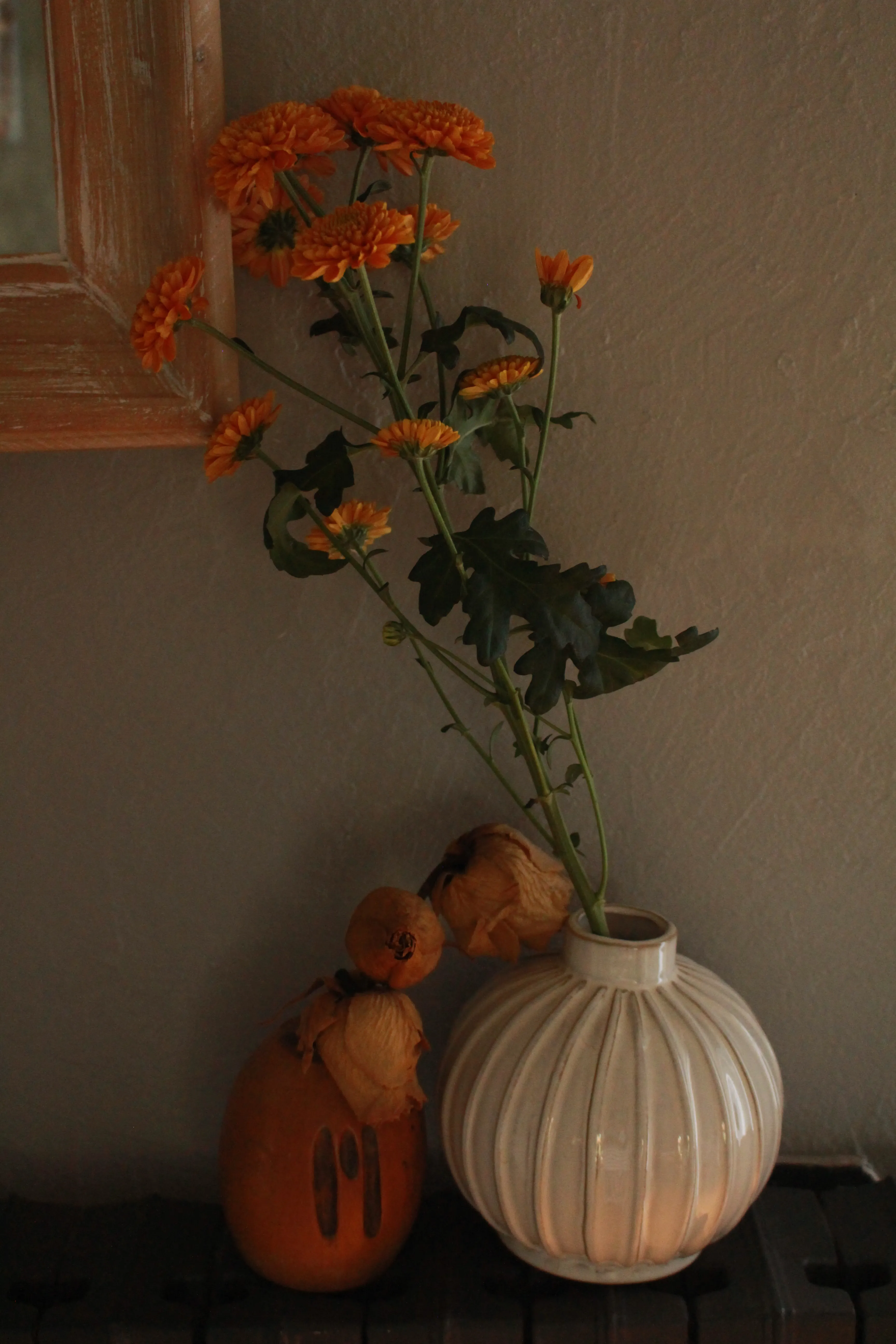 Vase avec fleurs oranges et fleurs séchées